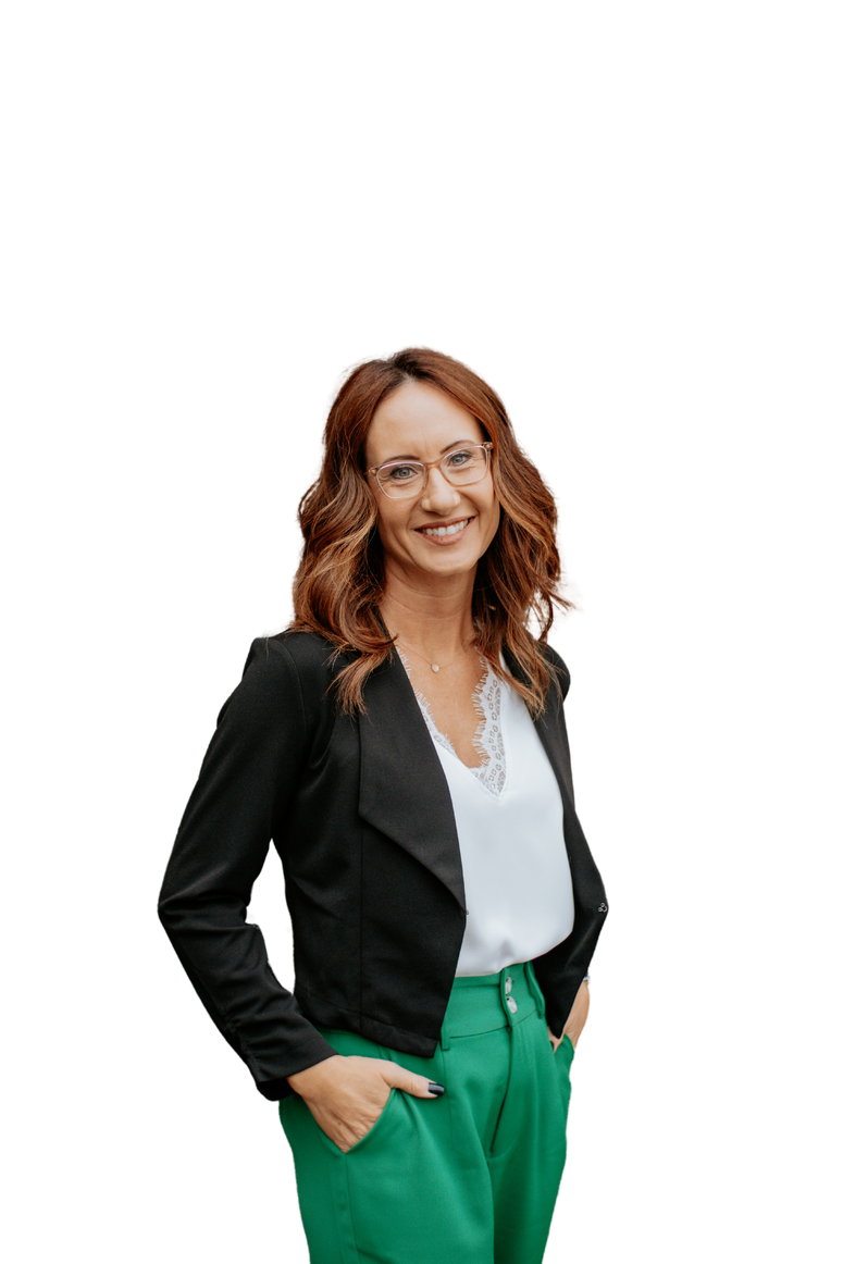 A smiling woman wearing green pants and a black blazer.